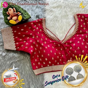 Pode incluir: Uma blusa vermelha vibrante com bordados dourados intrincados na gola, mangas e bainha. A blusa apresenta um design de decote em V e é adornada com pequenos padrões florais dourados. A imagem também inclui um par de brincos de prata e o texto "Get a Surprise Gift".
