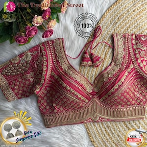 Könnte beinhalten: Eine magentafarbene Bluse mit aufwendiger goldener Stickerei. Die Bluse hat einen tiefen V-Ausschnitt und kurze Ärmel. Der Text "The Traditional Street" und "Premium Quality 100% Best Price" sind sichtbar. Eine Grafik "Get a Surprise Gift" ist ebenfalls vorhanden.