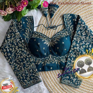 Puede incluir: Blusa de color turquesa con intrincados bordados dorados. Las mangas largas y el corpiño están adornados con motivos florales. La blusa tiene un escote de corazón y es de The Traditional Street.
