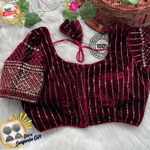 Pode incluir: Uma blusa de veludo bordô com listras verticais de lantejoulas e mangas adornadas. A blusa tem um decote redondo e um adereço de cabeça combinando. A imagem também inclui texto que diz "FAST DELIVERY", "PREMIUM QUALITY" e "Get a Surprise Gift".