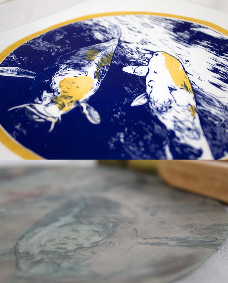 May include: A blue and gold print of two koi fish swimming in a circle. The fish are white with gold markings and are swimming in a blue circle with a gold border.