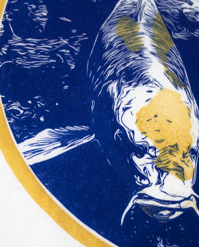 May include: A blue and gold circular print of a fish with white and yellow markings. The fish is swimming in a blue and white background.