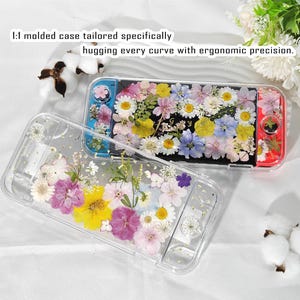 Puede incluir: Funda transparente para dispositivo de juego, llena de flores secas de colores. La funda tiene un diseño transparente, mostrando el arreglo floral. Texto en la funda: "1:1 molded case tailored specifically hugging every curve with ergonomic precision."