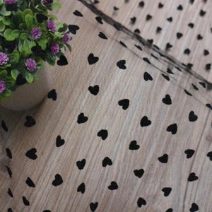 May include: Black tulle fabric with a repeating pattern of small black hearts.