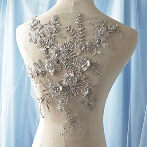 Può includere: Applique floreale argentata con fiori 3D e paillettes. Questo delicato pizzo è perfetto per aggiungere un tocco di eleganza agli abiti da sposa, agli abiti da sposa o ad altri abiti per occasioni speciali.