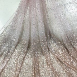 Könnte beinhalten: Nahaufnahme eines durchsichtigen Stoffes mit einem Farbverlauf aus silbernem Glitzer. Der Stoff ist leicht und luftig mit einer zarten Textur. Der Glitzer ist gleichmäßig über den Stoff verteilt und erzeugt einen schimmernden Effekt.