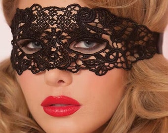May include: A black lace eye mask with delicate floral details. The mask covers the eyes and part of the nose, leaving the rest of the face visible.