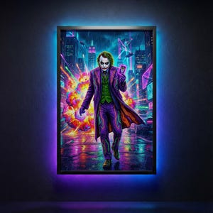 May include: Framed artwork featuring the Joker in a vibrant, neon-lit cityscape. The Joker, in a purple suit and green vest, holds a card. The background includes a colorful explosion and futuristic buildings. The frame has a black border with a blue and purple LED light.