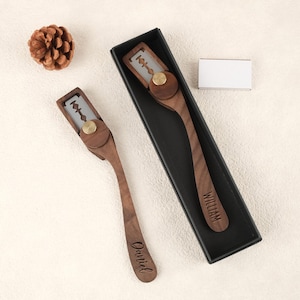 Op de afbeelding: Twee houten rechte scheermessen met een metalen mes en een messing accent. Eén scheermes zit in een zwarte doos, de andere wordt apart weergegeven. De handvatten zijn gegraveerd met de namen "William" en "Daniel".