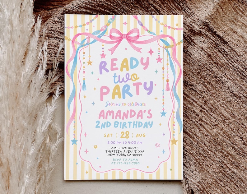 May include: A rectangular birthday invitation card featuring a yellow and white striped background with a pink bow, blue and pink ribbons, and hanging star and bead decorations. The text reads READY two PARTY, AMANDA'S 2nd BIRTHDAY, and event details.