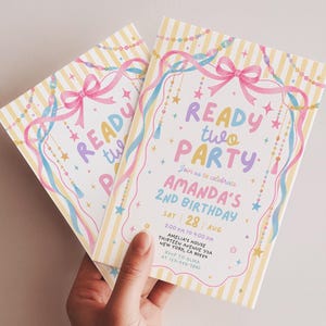May include: Two rectangular birthday party invitations with yellow and white vertical stripes. The text reads READY TWO PARTY, AMANDA'S 2nd BIRTHDAY, SAT 28 AUG, 2:00 PM TO 4:00 PM, AMELIA'S HOUSE, THIRTEEN AVENUE 73A, NEW YORK, CA 90554, RSVP TO ALMA AT 123-456-7890.