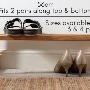 May include: A wooden shoe rack with two shelves. The top shelf is 56 cm wide and can fit two pairs of shoes. The bottom shelf is the same size and can also fit two pairs of shoes. The text "Sizes available for 3 & 4 pairs" is printed on the wall behind the shoe rack.