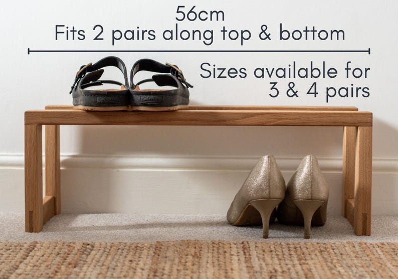 May include: A wooden shoe rack with two shelves. The top shelf is 56 cm wide and can fit two pairs of shoes. The bottom shelf is the same size and can also fit two pairs of shoes. The text "Sizes available for 3 & 4 pairs" is printed on the wall behind the shoe rack.