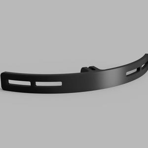 May include: A matte black curved bracket featuring a central mounting point and four elongated horizontal slots. The component has a smooth, solid finish and a semi-circular profile, designed with a uniform thickness throughout its structure.