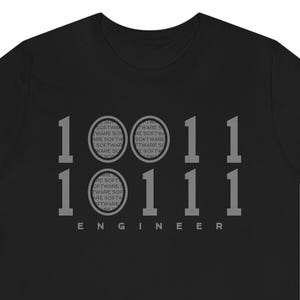 May include: Black t-shirt with a binary code design. The design includes the numbers 1 and 0, along with the word "ENGINEER" at the bottom. The binary code is accompanied by the word "SOFTWARE" in a circular pattern.