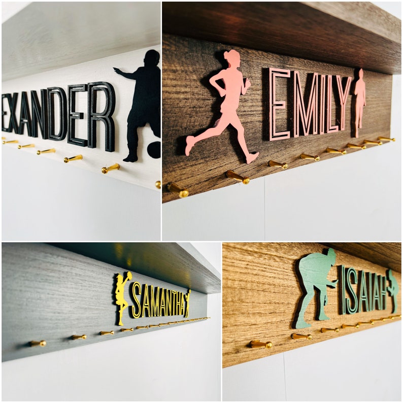 May include: Four wooden medal hangers with gold hooks. Each hanger features a different name, "Alexander", "Emily", "Samantha", and "Isaiah", with a silhouette of a person playing a sport. The hangers are painted in different colors: white, brown, gray, and brown.