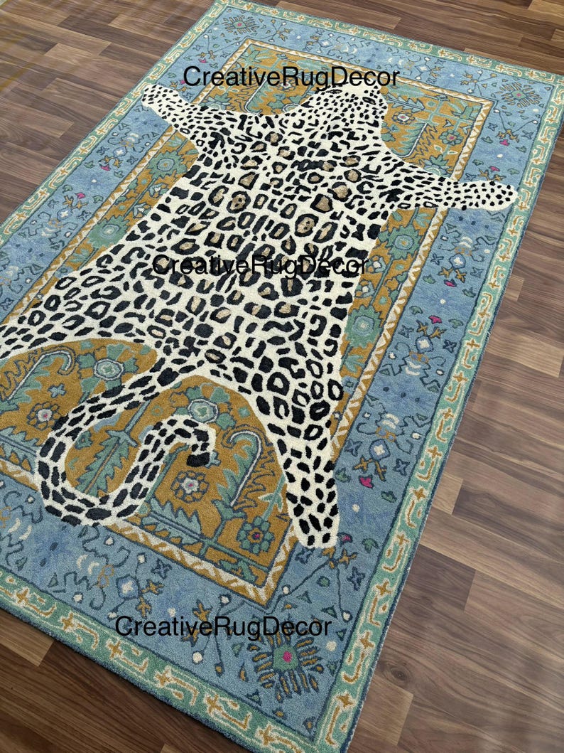 May include: A rectangular rug with a leopard print design in the center, surrounded by a blue and gold border. The rug has a distressed, vintage look. The text "CreativeRugDecor" is visible on the rug.