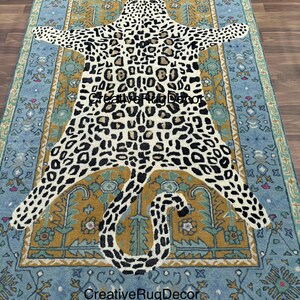 May include: A rectangular rug with a leopard print design in the center, surrounded by a blue and gold border. The rug has a distressed, vintage look. The text "Creative Rug Decor" is visible on the rug.