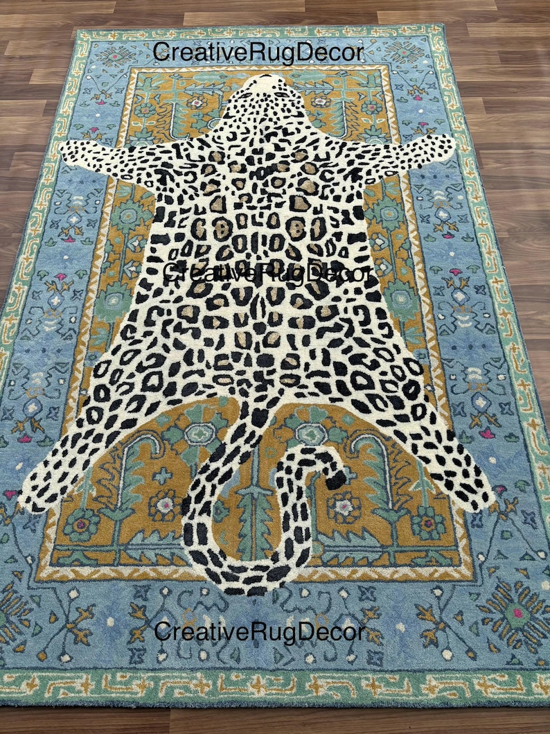 May include: A rectangular rug with a leopard print design in the center, surrounded by a blue and gold border. The rug has a distressed, vintage look. The text "Creative Rug Decor" is visible on the rug.