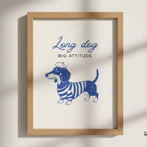 Puede incluir: Lámina enmarcada con un perro salchicha azul con boina y camisa a rayas. El texto "Long dog, BIG ATTITUDE" está escrito encima del perro. La obra de arte está en un marco de madera.