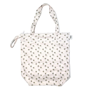 May include: White tote bag with a zipper closure and black bee pattern. The bag has two handles and a small tag that says "OGO".