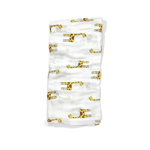 May include: White muslin baby swaddle blanket with a yellow and brown giraffe print.