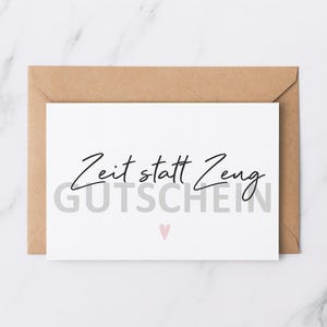 Könnte beinhalten: Eine weiße Karte mit dem Text "Zeit statt Zeug GUTSCHEIN" in Schwarz und Grau, mit einem kleinen rosa Herz. Die Karte befindet sich in einem braunen Umschlag.