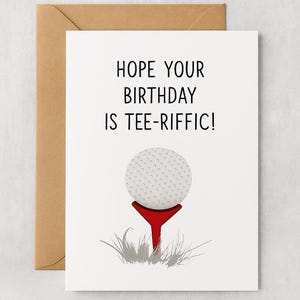 Könnte beinhalten: Eine weiße Geburtstagskarte mit braunem Umschlag. Die Karte zeigt einen Golfball auf einem roten Tee mit dem Text "HOPE YOUR BIRTHDAY IS TEE-RIFFIC!" in Schwarz.