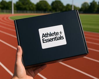 May include: A black box with a white sticker that says "Athlete Essentials" and a running figure icon. The box is being held in front of a red running track.