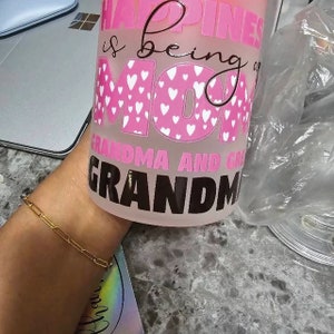 a woman's hand holding a pink coffee mug