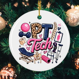 May include: A round white ceramic ornament featuring the text PT Tech in pink and leopard print. Illustrations include a pink exercise ball, blue dumbbell, medical tape, treatment table, human spine, pelvis, foam roller, walker, and crutch.