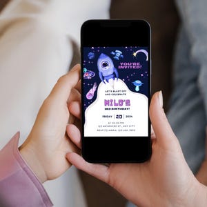 Puede incluir: Una invitaci&oacute;n digital para una fiesta de cumplea&ntilde;os de 3 a&ntilde;os con tem&aacute;tica espacial. La invitaci&oacute;n presenta una nave espacial de dibujos animados, planetas y estrellas sobre un fondo azul oscuro. El texto dice "&iexcl;Est&aacute;s invitado! &iexcl;Despegamos y celebramos el 3er cumplea&ntilde;os de Milo! Viernes, 20, 2024 a las 14:00, 123 Anywhere St., Any City, RSVP a Maria: 123-456-7890".