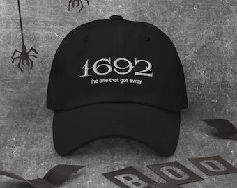 May include: Black baseball cap with white embroidered text that reads "1692 the one that got away".