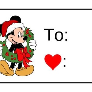 May include: A Christmas gift tag featuring Mickey Mouse wearing a Santa hat and holding a green wreath with red berries. The tag says "To:" and has a red heart.