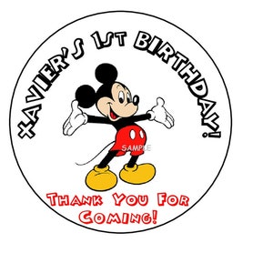 May include: Round white sticker with a black outline. The sticker features a cartoon image of Mickey Mouse in color. The text "Javier's 1st Birthday!" is written in black around the top of the sticker. The text "Thank You For Coming!" is written in red around the bottom of the sticker.