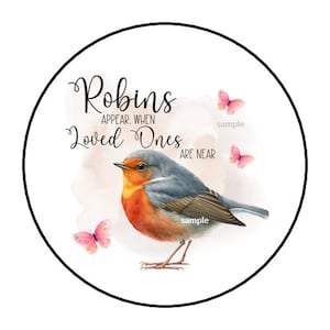 May include: A watercolor painting of a robin with the text "Robins appear when loved ones are near". The robin is perched on a branch with pink butterflies in the background.