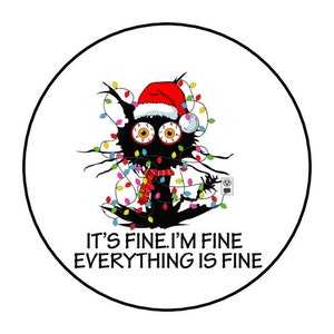 May include: A round sticker featuring a cartoon black cat with large, wide eyes, wearing a Santa hat and a red scarf, tangled in Christmas lights. The text "IT'S FINE. I'M FINE EVERYTHING IS FINE" is below the cat.