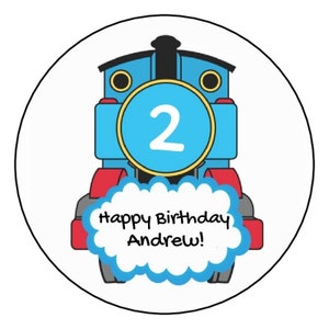May include: A blue and red cartoon train engine with a yellow circle around the front. The circle has the number 2 in white. A blue cloud with the text "Happy Birthday Andrew!" is in front of the train.