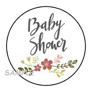 May include: A white circle with a black outline, featuring the text "Baby Shower" in gray cursive lettering. A floral design with pink, green, and yellow flowers and leaves surrounds the text. The word "SAMPLE" is printed in gray at the bottom of the circle.