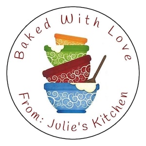 May include: Round sticker with a white background and red text that reads "Baked With Love From: Julie's Kitchen".  The sticker features a stack of four colorful mixing bowls with a wooden spoon.
