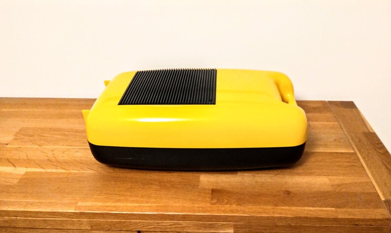 May include: A yellow and black portable cassette player with a black grill on the top.