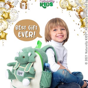 May include: A green corduroy backpack with a dinosaur design, a side pocket holding a water bottle, and the text "BEST GIFT EVER!". The backpack is labeled "MEDIUM BACKPACK 5-9 y.o." and features the "Naturally KIDS" logo.