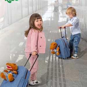 May include: Two children pulling denim blue rolling backpacks with brown dinosaur stuffed animals. The backpacks have black handles and wheels. The image includes the text "Naturally KIDS" in green.