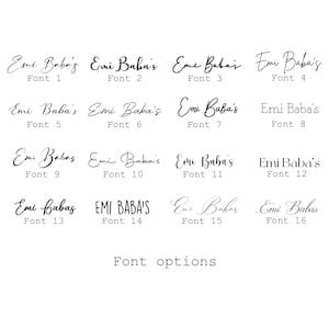 May include: A white background displays sixteen different font options for the name "Emi Baba's", each labeled with a font number. The text "Font options" is below the font samples. The fonts vary in style, from elegant cursive to bold sans-serif.