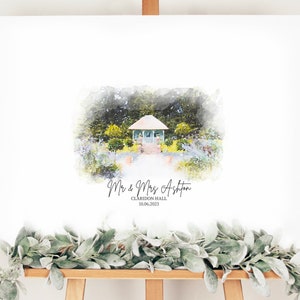 May include: A white wedding sign on an easel featuring a watercolor painting of a gazebo in a garden. The sign includes the names "Mr & Mrs Ashton", the venue "Claridon Hall", and the date "10.06.2023". A garland of green leaves adorns the bottom.