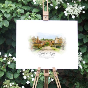 May include: A watercolor-style wedding sign on a wooden easel, featuring a detailed illustration of a stately building. The sign includes the names "Sophie & Ryan" and the date "1st July 2023", set against a backdrop of lush greenery.