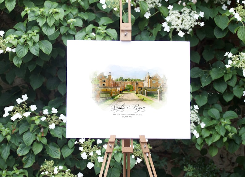 May include: A watercolor-style wedding sign on a wooden easel, featuring a detailed illustration of a stately building. The sign includes the names "Sophie & Ryan" and the date "1st July 2023", set against a backdrop of lush greenery.