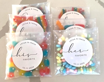 Peut inclure: Plusieurs sachets translucides à pois blancs remplis de bonbons colorés assortis. Chaque sachet porte une étiquette blanche circulaire imprimée avec "chloe & reese" et "his FAVORITE" ou "her FAVORITE" ainsi que la date "10.17.2026".