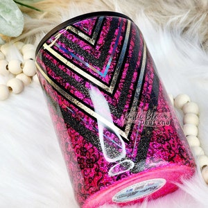 May include: A pink and black tumbler with a gold geometric design. The tumbler has a black and white lace pattern and a gold glitter finish. The tumbler is labeled "Kistic Bloom Designs".
