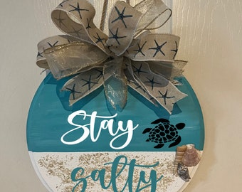 Stay salty beach welcome porch, patio and door decor with real beach sand and shells. Beach house welcome sign.
